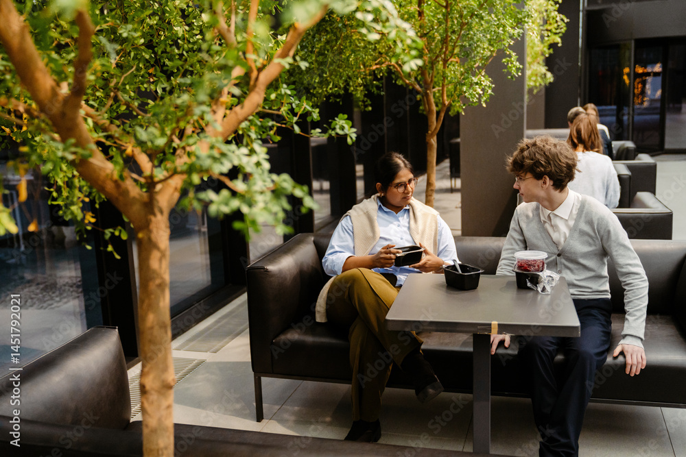 custom made wallpaper toronto digitalA dark-haired European man in his early 20s talks to an Indian adult woman over lunch on a terrace while other multi-ethnic colleagues eat behind him.