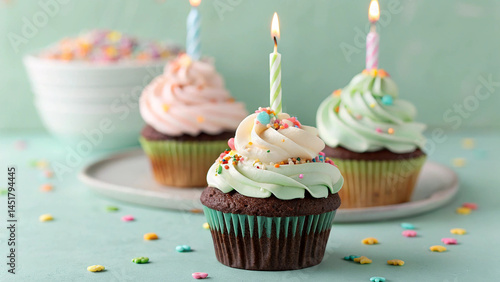Festive Cupcake Trio with Lit Candles, Colorful Frosting, and Sprinkles on a Light Green Surface in a Joyful Celebration Scene