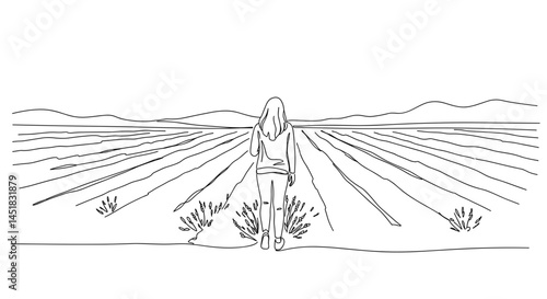 Young woman contemplating in a field with distant mountains  