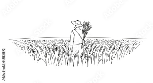 Farmer standing in wheat field holding sheaf of grain  