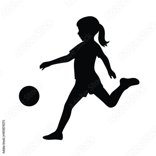 Silhouette of a young girl playing soccer, kicking the ball