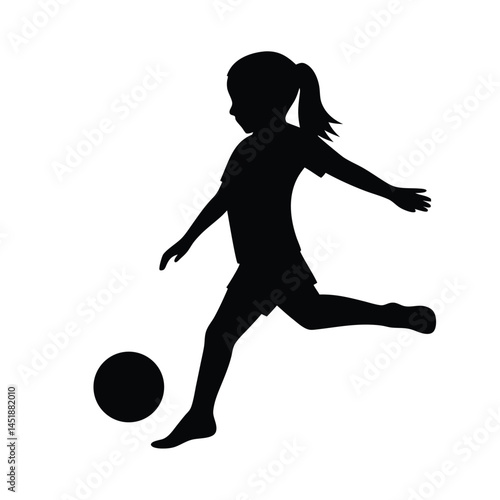 Silhouette of a young girl playing soccer, kicking the ball