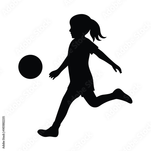 Silhouette of a young girl playing soccer, kicking the ball