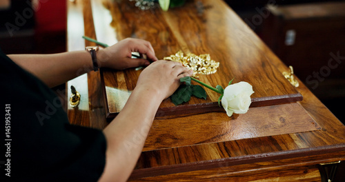 Fotografie Hands, person and flower on coffin at funeral for farewell, mourning death and goodbye at burial ceremony