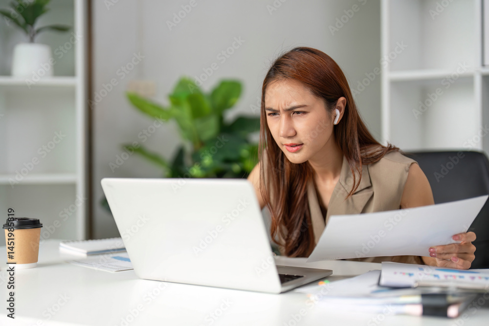 Work Online and Focused Analysis. A young professional shows concentration and determination while analyzing documents at her workstation. Work Online and Focused Analysis. A young professional shows concentration and determination while analyzing documents at her workstation.