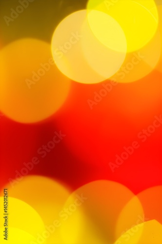 Soft bokeh effect created by christmas lights in warm gold and red tones