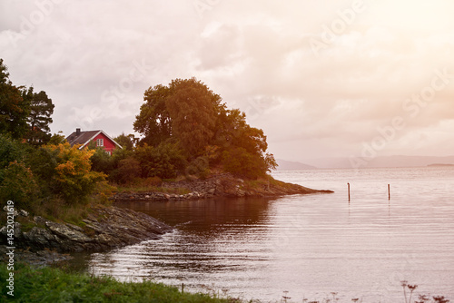 Obraz na płótnie Red house by lake with mountains in background w salonie