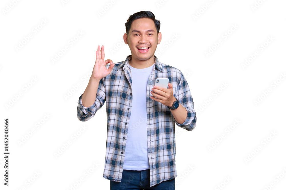 Cheerful young Asian man in plaid shirt using mobile phone and showing okay sign gesture, recommend application isolated on transparent background Cheerful young Asian man in plaid shirt using mobile phone and showing okay sign gesture, recommend application isolated on transparent background
