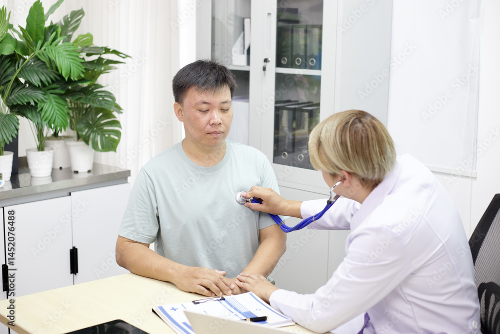 Fototapeta premium Doctor performs medical checkup on patient using stethoscope in clinic
