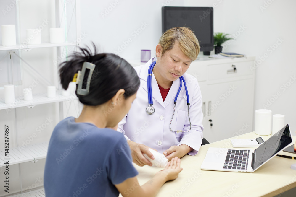 Fototapeta premium Doctor in white coat attentively examines patient hand in medical office