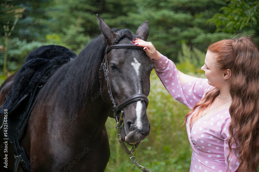 Obraz premium Woman gently caressing her horse in a green forest setting