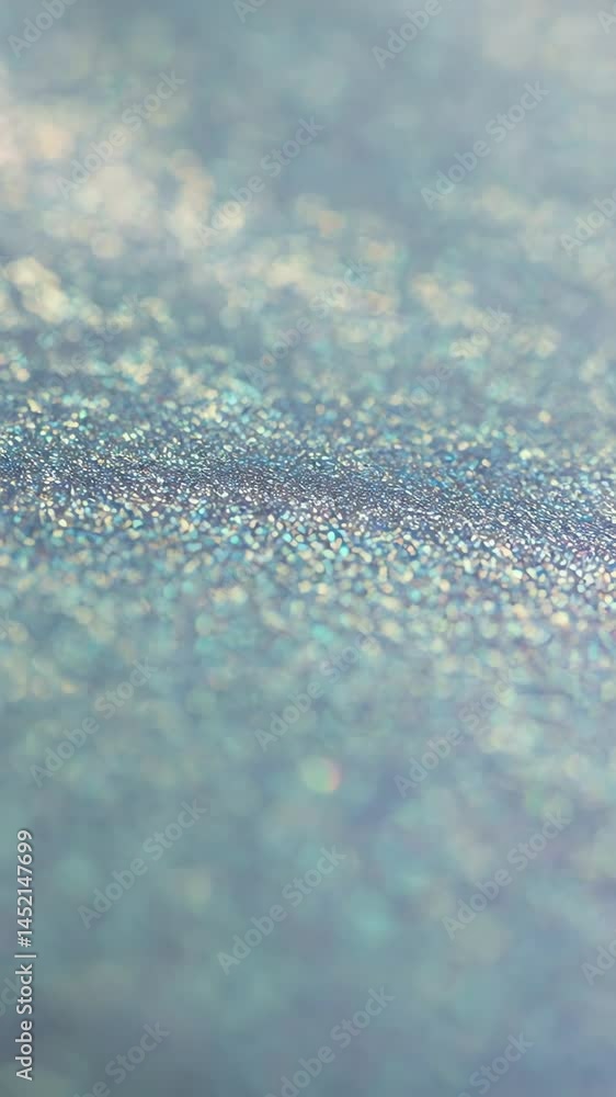Close-up of subtly iridescent surface with fine glitter particles catching light, suitable for elegant intros or soft backgrounds Close-up of subtly iridescent surface with fine glitter particles catching light, suitable for elegant intros or soft backgrounds