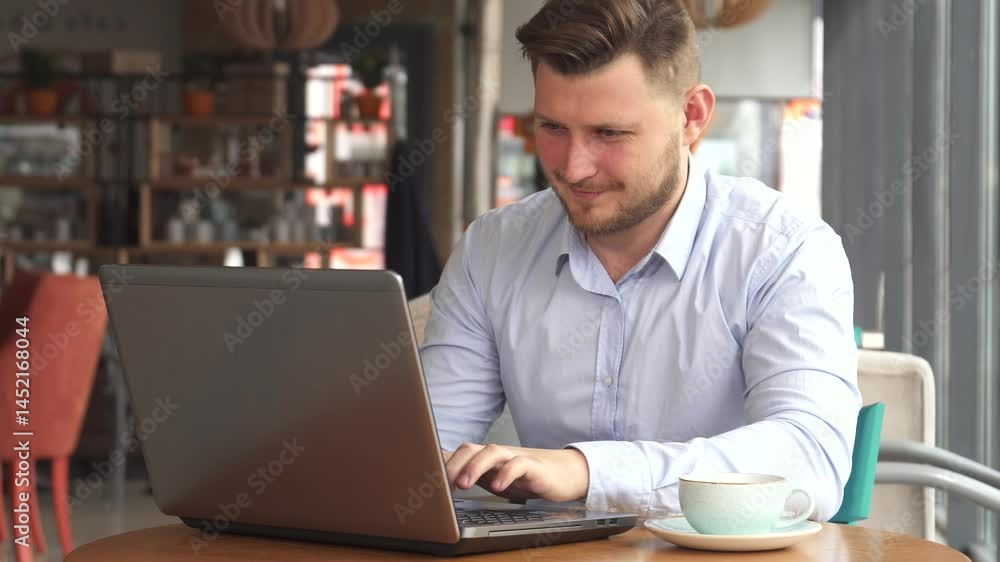 Focused businessman immersed in work at a cozy cafe Focused businessman immersed in work at a cozy cafe