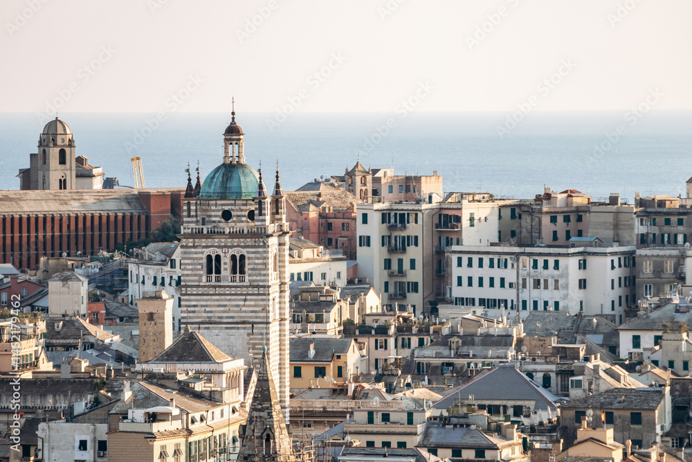 Obraz premium View of Genoa's rooftops at sunset, showcasing the city’s historic skyline and warm golden light.