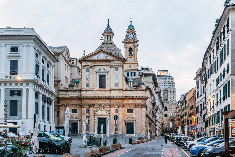 Naklejka premium Genoa, Italy - September 22, 2024: Baroque facade of Basilica di San Siro with statues and green doors faces lively square in city center.