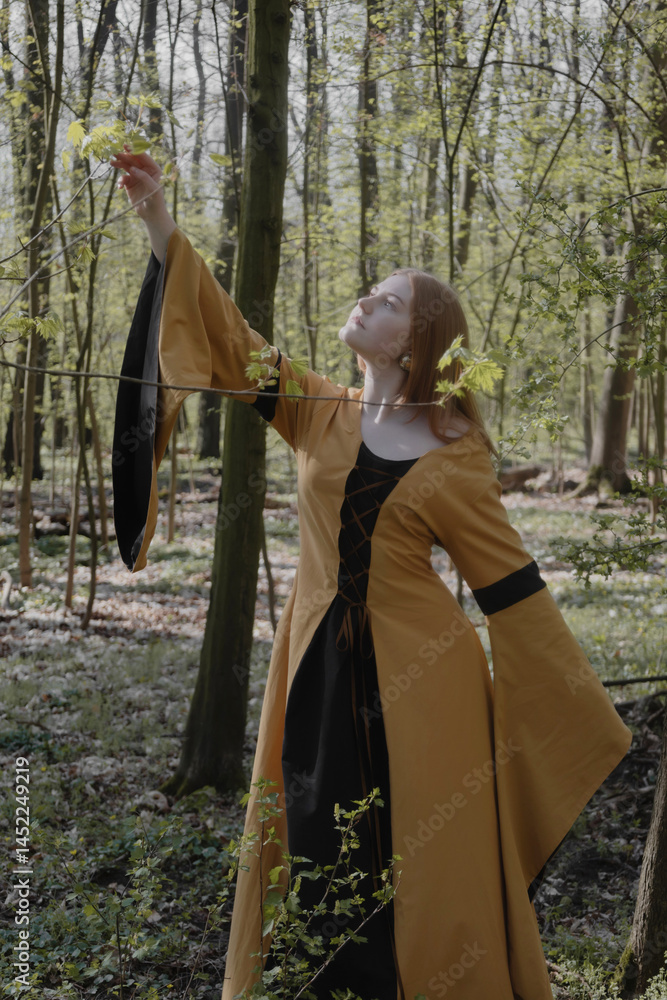 young woman in medieval dress in spring forest