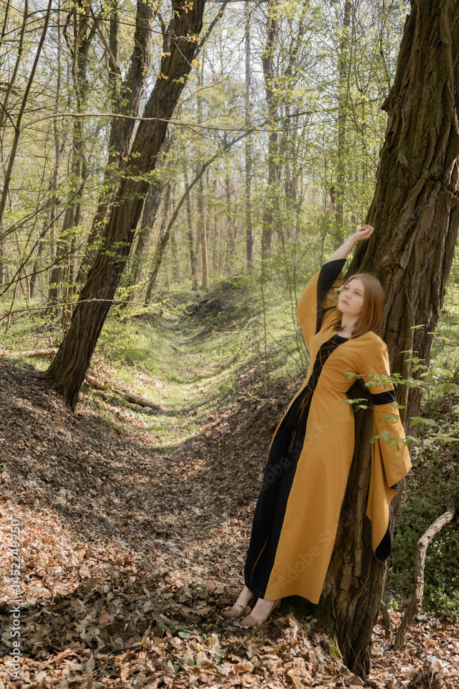 young woman in medieval dress in spring forest