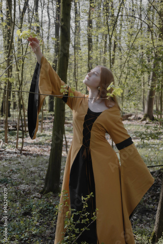 Obraz na płótnie young woman in medieval dress in spring forest w salonie