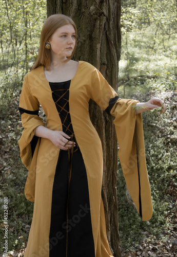 Obraz na płótnie young woman in medieval dress in spring forest w salonie