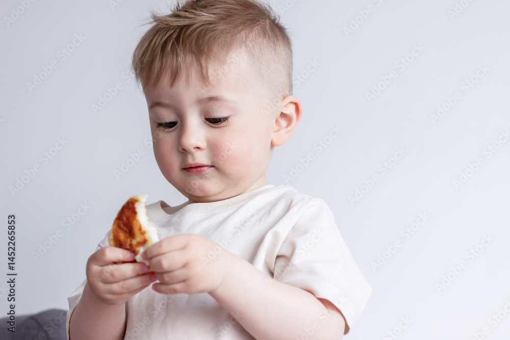 A piece of bitten pancake in a child's hands, a child eats pancakes A piece of bitten pancake in a child's hands, a child eats pancakes
