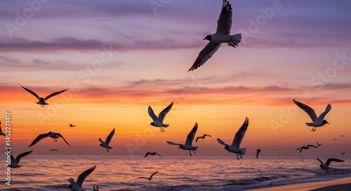 Wallpaper Mural Dynamic Flock of Seagulls Silhouetted Against Twilight Sky with Vibrant Hues of Orange Purple and Pink Over Gentle Waves on Coastal Beach Captured in Wide Angle Torontodigital.ca