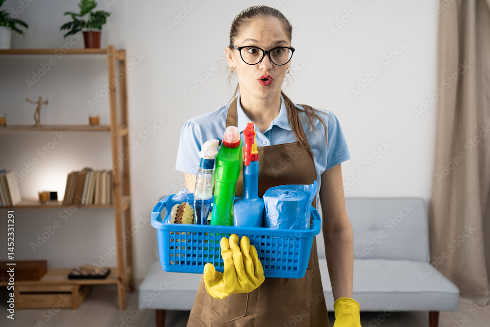 Cleaner woman wearing apron holding cleaning products in basket standing in the living room looking skeptical surprised. Cleaning Cleaner woman wearing apron holding cleaning products in basket standing in the living room looking skeptical surprised. Cleaning