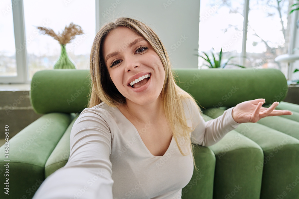 Selfie portrait happy beautiful young woman in home interior