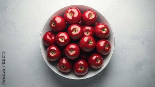 Obraz na płótnie A white ceramic bowl overflowing with red apples, placed centrally on a pure white surface, photographed from top view. Clean lighting with soft shadows. Created Using: DSLR overhead shot, w salonie