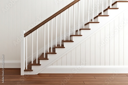 Wooden staircase with white paneling and a wooden railing.  Interior view with hardwood floors