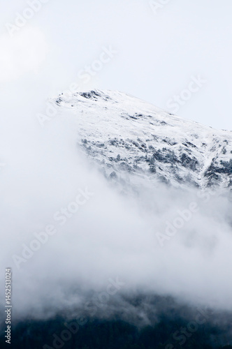 Mountain peak fading into dense clouds