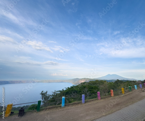 Scenic viewpoint overlooking tranquil lake and distant mountains at sunset