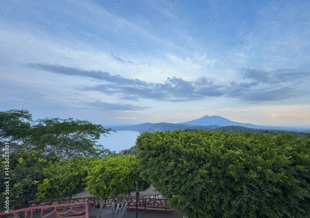 Majestic landscape view of serene lake with mountains in background at sunset