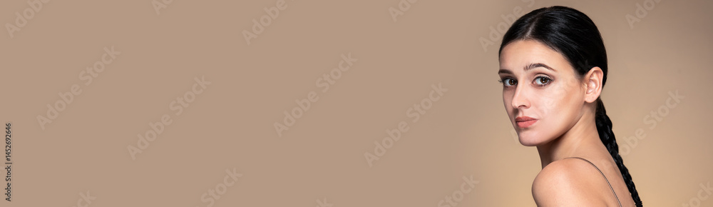 Banner with beauty studio portrait of young beautiful woman against beige background.