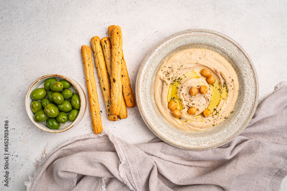 Various hummus dips in different colours. Hummus with dry crackers, top view. Vegan and traditional hummus as healthy and vegan snack.