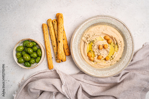 Obraz na płótnie Various hummus dips in different colours. Hummus with dry crackers, top view. Vegan and traditional hummus as healthy and vegan snack. w salonie
