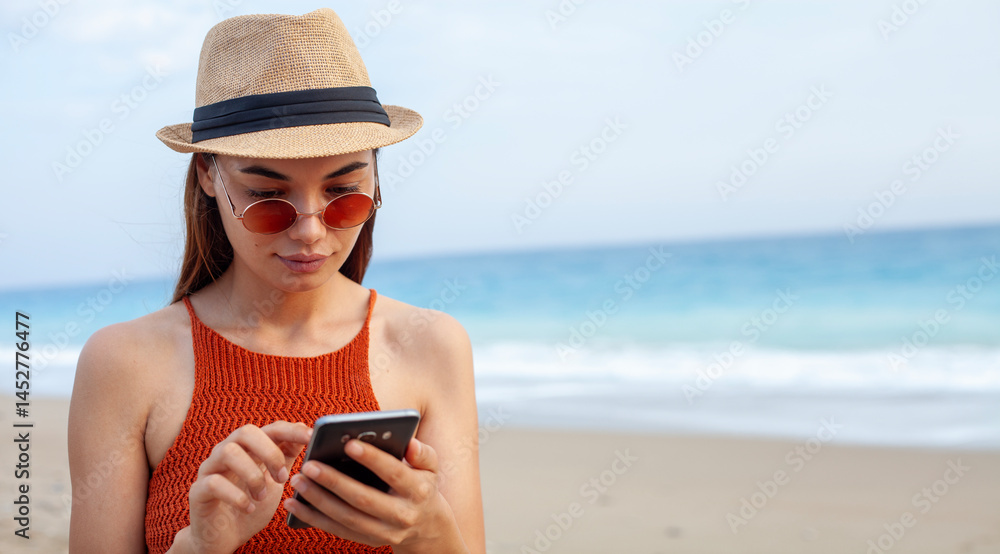 Obraz premium woman using smart phone at the beach