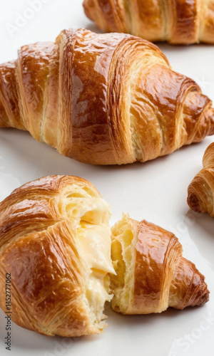 Obraz na płótnie Freshly baked croissants arranged on a clean white plate, perfect for breakfast or snack w salonie