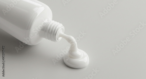 A minimalist studio shot of a white tube releasing a creamy white product