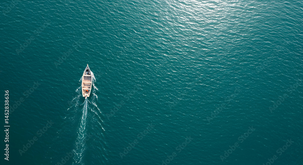 Fototapeta premium Aerial View of a Single Boat Sailing Over Calm Blue Waters