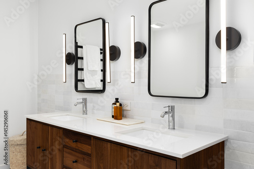 Εκτύπωση καμβά A bathroom detail with a dark wood vanity cabinet, white marble countertop, black sconce lights around metal mirrors, and a marble tiled backsplash