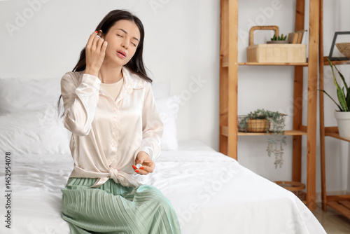 Young woman with otitis usi...