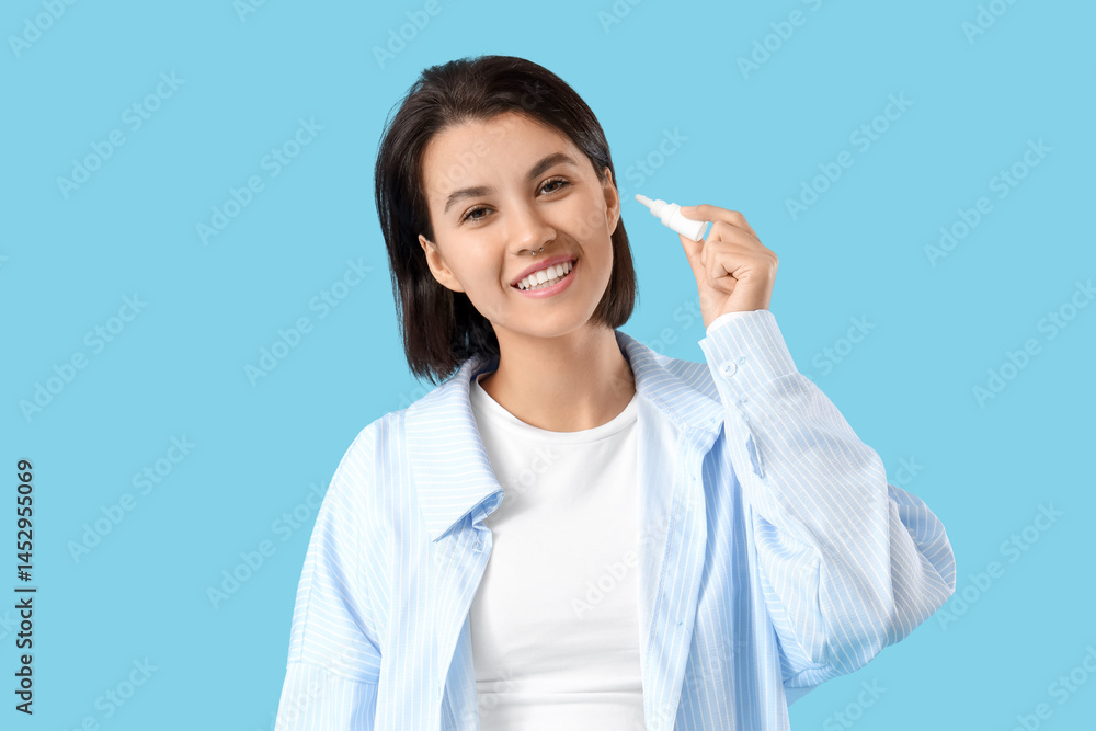 Young girl with ear drops on blue background Young girl with ear drops on blue background
