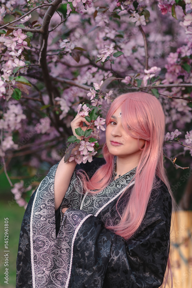 Fototapeta premium Girl in anime kimono next to pink apple tree