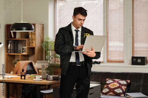 Male FBI agent using laptop...