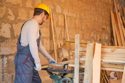 Male carpenter sawing woode...