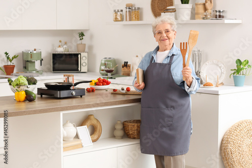 Senior woman with spatulas ...