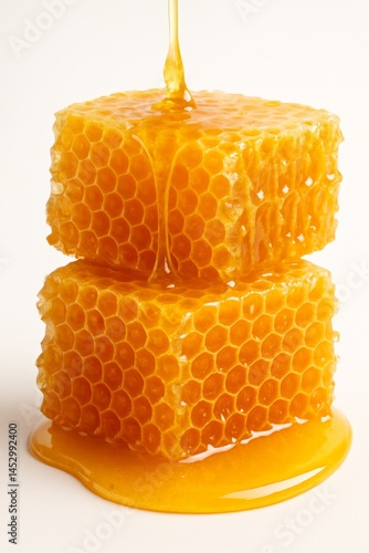 Honey Dripping From Fresh Honeycomb Blocks on a White Background Showcasing N...