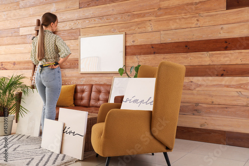 Young woman decorating home...