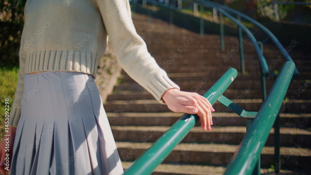 Woman hand touching rails walking sunshine staircase closeup. Lady relaxing