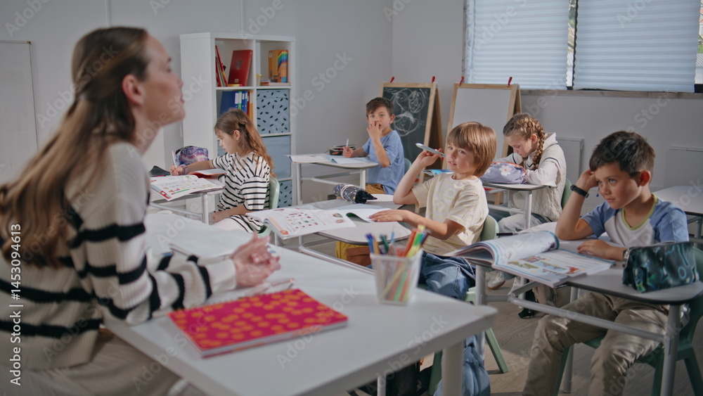 Clever schoolchildren looking educator in classroom closeup. Teacher asking